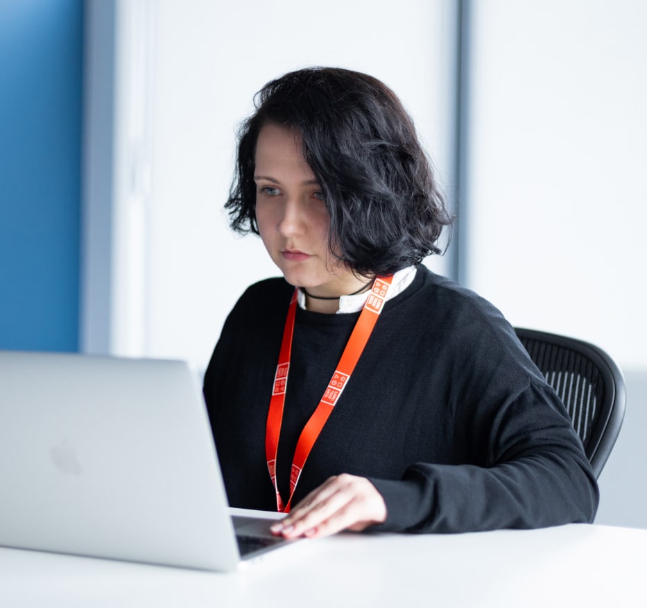 Woman working on a laptop, representing data annotation team solving GIS labeling and segmentation challenges