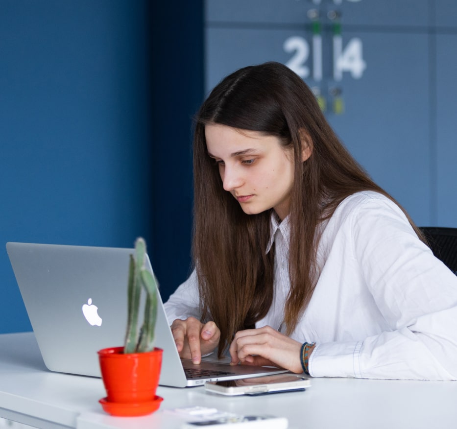 Woman working on a laptop, representing the team addressing data annotation and tracking challenges for AI projects
