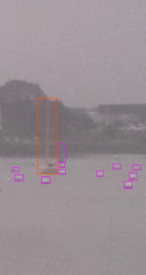 Video frame with bounding boxes marking boats and objects for computer vision model validation